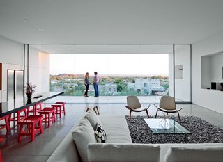 For the seating area, the couple selected a Charles sofa by Antonio Citterio for B&B Italia in addition to CH07 Shell chairs by Hans Wegner, a PK61 coffee table by Poul Kjærholm, and a Nesta rug from Design Within Reach. The dining table, an original design by Burnette, is surrounded by stools that belonged to a previous owner.