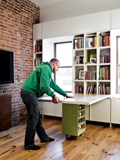 Storage-Smart Renovation in New York City - Photo 10 of 14 - The table’s base, which itself is an additional storage container, rolls easily into place to support the surface.
