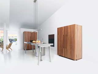 Bulthaup's B2 Kitchen System - Photo 1 of 2 - Bulthaup's b2 system comes equipped with everything a kitchen needs—the workbench contains a sink, trash receptacles, and cooktops, while the two wooden cabinets house the appliances and the kitchenware.