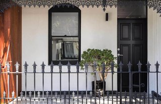 The home’s white stucco walls and chestnut-hued timber offer a modern contrast to its filigree railing and ornamentation.