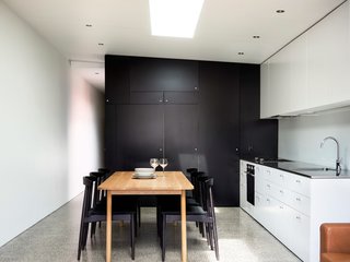 The home’s minimalist kitchen demonstrates that you can create something beautiful without shelling out too much cash. To help stretch the budget, Abicic installed generic fixtures and cabinets. The dining room chairs and table were purchased secondhand.