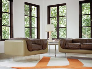 To highlight the existing architecture of the home, Hill retained the dark polish of the casement windows, which she finds enhances period details instead of undermining them. In the rear sunroom, the vintage Case Study furniture pieces with Plexiglas bases are from Metro Retro in Houston.<br><br>A Bourgie lamp by Kartell is atop an old marble end table by Knoll, and the Gan kilim rug pictures a branch motif echoed in the kitchen and breakfast room.