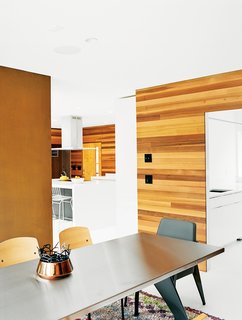 The contractor, Tim Kimmel of Kimmel Builders, removed built-in shelving behind the stone fireplace and installed a Cor-Ten steel panel in its place. Vitra manufactures the Jean Prouvé–designed Standard dining table and side chairs.