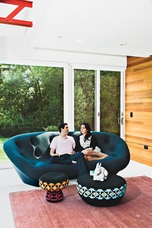 Steven and Tata relax in their living room. "The house has always been deemed the ‘great escape,’" says Steven. "It’s a very special place for us." The Superheroes stool and table are by Swedish designers Glimpt Studio for Cappellini, the blush-colored rug is from ABC Carpet & Home, and the Pan Pan rabbit figurine is by Ligne Roset.