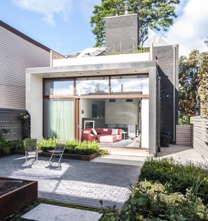 15 Modern Additions to Traditional Homes - Photo 11 of 15 - In the rear of the house, a new addition extends the living space and adds a roof terrace off the second-floor master bedroom. A garden is accessible through a wall of sliding glass doors with Sapele mahogany frames, set back to control solar gain.