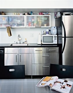 Burnished concrete floors complement the stainless steel doors, refrigerators, and kitchen cabinets.