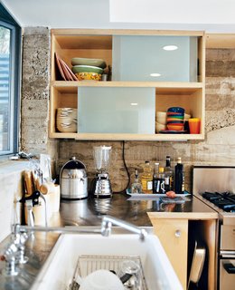 There are precious few decorative flourishes in the house; the architects put their faith in line, form, and materials. Concrete, stainless steel, and birch were used in the kitchen, where not an inch of space goes unused.