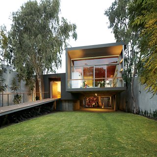 A Modern Concrete Home in Peru - Photo 1 of 13 - The entrance is reached via a long ramp perforated by uplights.