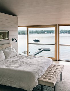The bed and bench are from Desiron; the wall sconces are by Arne Jacobsen for Louis Poulsen. The operable windows and doors throughout are by Bayerwald.