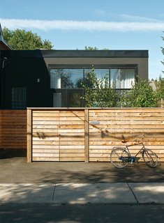 Monkman’s house has a quiet presence, its front half hidden behind a fence of cedar two-by-sixes.