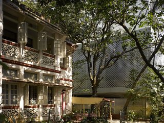 A Modern Aesthetic in Mumbai - Photo 4 of 17 - Somewhat by chance, the apartment building's aluminum core references the perforations of the house next door; its interior breezeways also echo those of the neighboring structure.