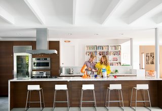 The once-hermitic kitchen now has a direct view of the patio and pool. The hood is by Zephyr, the cooktop is by Miele, the refrigerator is by Sub-Zero, the ovens are by GE Monogram, and the stand mixer is by KitchenAid.The Sebastian barstools and Trådig fruit bowl are also from Ikea.