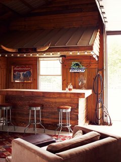 A Modern Farmhouse Recalls Old-Time Americana - Photo 6 of 10 - Inside, Paul often dispenses whiskey to friends from behind the rustic bar.