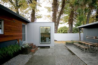 Two converted shipping containers (left) now house offices for Shoup’s design/build firm. "Perhaps the most successful aspect of turning this into a place to live and an office rather than just have this shop space was moving it towards real indoor-outdoor living," he says. Taya Shoup, a landscape designer, has refined her husband’s vision for the property with a courtyard and plantings. Photo by building Lab inc.