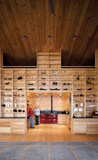 The kitchen, complete with an Aga stove, is framed by modular shelves and helps heat the sleeping nook directly above it.