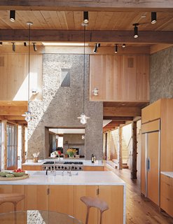 PISE Does It - Photo 2 of 4 - The house has the feel of a refined barn: The kitchen flows into the dining area, then into a den. The two PISE "chimneys" serve to demarcate the transitions and visually unite the space.