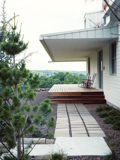 A Modern Farmhouse Recalls Old-Time Americana - Photo 9 of 10 - The homeowners call the house Porch House after it's majestic wraparound porch.