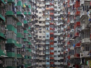 From a distance, the buildings resemble geometric patterns. However, close inspection reveals laundry, mops and other signs of domestic life. Photo by Michael Wolf, courtesy of the Flowers Gallery.