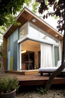 The lantern addition includes tall sliding doors topped by a frieze of windows to help elevate the light that now pours into the home, which was much darker before the renovation. At left is a load-bearing shear wall that pulls in colors from elements within the house’s existing palette.