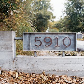 Schatz and Eamon bought a small sheet of copper, cut out their house numbers, mixed and poured some concrete, and voilá-- their own groovy house numbers for $125.