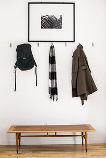A Versatile House Fulfills All This Musician's Needs - Photo 2 of 11 - Inside the front door, coats hang from aluminum Bjärnum hooks by Ikea above a vintage Lane coffee table, which Magill bought from a coworker, and beneath a photograph by Beth Mercer.