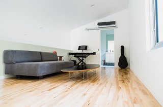 A Versatile House Fulfills All This Musician's Needs - Photo 4 of 11 - The loft is furnished with a Tillary sofa from West Elm and a wire-base Elliptical table by Charles and Ray Eames.