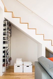 A Versatile House Fulfills All This Musician's Needs - Photo 5 of 11 - The staircase features a minimalist design with maple treads and edges. The alcove beneath the stairs allows Magill to stash things where they can still be easily accessed. The metal shelving system is another coworker castoff.