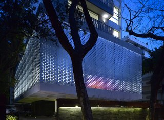 A Modern Aesthetic in Mumbai - Photo 2 of 17 - The perforated aluminum cladding surrounds the lower-level public area, which contains the pools and gym for the tenants. Khanna and Schultz played with the idea of using stainless steel, but found that aluminum had the appropriate strength for the building's needs. "With the lights glowing from inside, it turns the whole building into a big lantern at night," says Schultz.