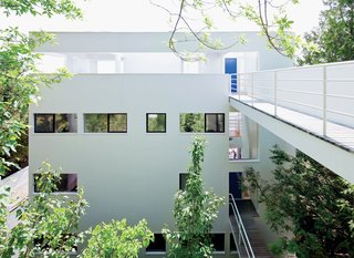 This Lake House Is a Living Piece of Architecture History - Photo 1 of 21 - Nestled into the hillside and largely concealed from view, the Douglas House is accessed via a footbridge that leads to the house’s uppermost level. Upon entering, the visitor descends to the lower floors via a winding staircase.
