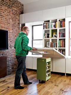 Storage-Smart Renovation in New York City - Photo 5 of 14 - When it’s time to eat or do homework, the adults lower the tabletop, revealing a dozen book cubbies.