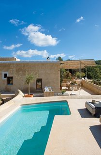 Discover 8 of the Best Mediterranean Homes - Photo 8 of 11 - The architects discreetly sunk a pool into the roof terrace of the old corral. In order to shade part of the terrace, they designed a freestanding sun shelter. So as not to damage the outer walls of the old building, a galvanized-steel frame is secured to the terrace floor. A bamboo-reed covering projects a soft, filtered light onto the outdoor living area below.