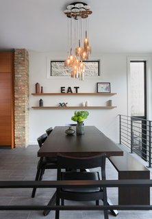 Julie Fisher on How to Shop for Furniture - Photo 1 of 2 - In the dining room, Fisher opted for a Cross Extension table and Profile chairs from Design Within Reach and a custom bench by JJ Woodwork. The Spillray pendants are by Axolight.
