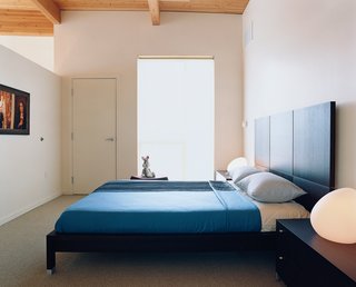Community Building - Photo 4 of 10 - The simple, spare bedroom is brought to life by Rapaport’s toy Bugs Bunny and a pair of egg-shaped Dolmen table lamps designed by Philippe Daney for Ligne Roset. The Lumeo bed is also by Ligne Roset and was designed by Peter Maly.