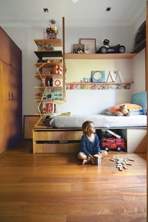 6 Ways to Declutter and Free Up Space in Your Bedroom - Photo 3 of 8 - Tom’s compact bedroom feels much larger thanks to interlocking shelves and storage. The plywood bed and surrounding shelving were custom-built by Wilkin and a hired carpenter.
