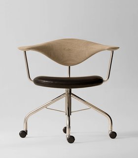 8 Iconic Chairs by Hans Wegner - Photo 8 of 9 - During a Danish furniture trade show, Dr. Eigill Snorrason critiqued the industry for not paying enough attention to ergonomics. The Swivel Chair (1955) Wegner’s rejoinder of sorts, an elegant backrest of hand-carved wood that’s been compared to a gently bent propeller. The smooth lines, thin profile and wheels invite a sure-footed slide across any office. Manufactured by PP Møbler. Photo by Jens Mourits Sørensen.