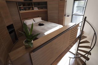 Upstairs is a sleeping loft, accessible by a spiral staircase. A digital projector makes it possible for the couple to watch movies against the opposite wall.