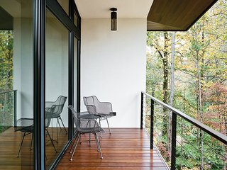 Wire chairs by Rejuvenation and ceiling-mounted fixtures by Hinkley Lighting grace the balcony outside.