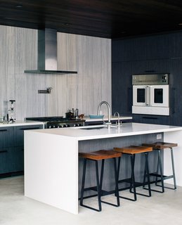 Modern Home Designed for Live Music in Beverly Hills - Photo 5 of 10 - In the kitchen, Walker continued an earthy color scheme. The range and wall oven are by BlueStar, the hood is from Zephyr, and the island is Caesarstone.
