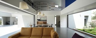 A Home That Dramatically Replicates a Starry Sky in Its Living Room - Photo 6 of 9 - The living room, sandwiched between the North garden and South courtyards, features operable windows that make for seamless indoor-outdoor living. Tolomeo Mega Parete light fixtures by Artemide hang over the dining and living areas.