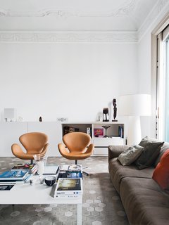 12 Creative Ways to Use Tile in Your Home - Photo 9 of 12 - In the living room of the Barcelona apartment designer Elina Vila D’Acosta-Calheiros shares with her husband, Ginés Gorriz, Arne Jacobsen Swan chairs join a sofa by Piero Lissoni for Living Divani. The cabinet is from Cappellini, as is the Marcel Wanders Big Shadow lamp.