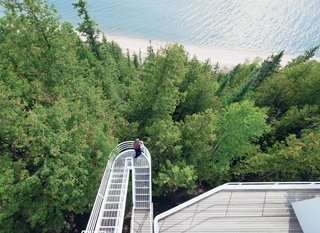 This Lake House Is a Living Piece of Architecture History - Photo 5 of 21 - Located on the shore of Lake Michigan, the 1973 Douglas House was one of architect Richard Meier’s first residential commissions. Defined by its verticality, the house features an exterior stepped walkway that extends over the trees, connecting the levels.