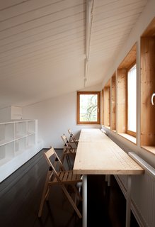 Near custom pine shelving on the third floor, folding chairs and a table from IKEA provide a tranquil space for studying.
