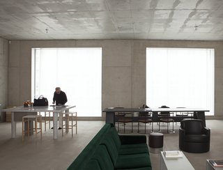 7 Modern Architects at Home - Photo 4 of 9 - "First his studio, then his home. David Chipperfield chose Berlin, after the city commissioned him to rebuild the Neues Museum in 1997. It is in the same neighborhood, Mitte. In the courtyard that contains both his house and his studio, Chipperfield also designed a canteen, a place where locals meet. The house is built of concrete, with large windows overlooking the street and the courtyard. It contains a few ’50s and ‘60s Italian furnishings, and two colours. The green of a velvet sofa and the orange of a bookcase that divides the space between the kitchen and the sitting room." 