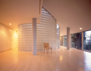7 Modern Architects at Home - Photo 8 of 9 - "Hanegi Forest–architecture among trees, designed by Shigeru Ban in 2007. The challenge was to avoid pulling down a single tree in the forest and to build a house around them. Shigeru Ban’s home is in this building, which stands immobile in a tranquil Tokyo district. A round table, a Terragni chair, a Greek face and masses of light. Nothing else, a Zen monk’s room." 