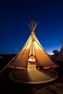 Here, one of El Cosmico's three teepees is a lantern for desert travelers.