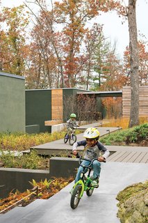 To combat the site’s steep, uneven grade, Boeschenstein staggered a series of ipe decks around the two main volumes of the house. Atticus joins his brother, Bodhi, on the zigzag decks.