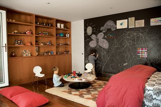 A Garage Converted Modern Playroom - Photo 4 of 4 - Writing on the walls is encouraged by the magnetic slate chalkboard from Claridge Products. The Phoenix table by Patricia Urquiola for Moroso does double duty as a play table or a coffee table, depending upon who’s in residence. The Tulips felt rug is from Peace Industry, and was made in a fair-trade workshop in Iran. The casework is constructed of anigre wood.