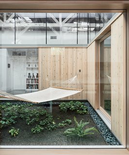 The living areas and an office are arranged in an open layout around a central atrium that is open to the outdoors.