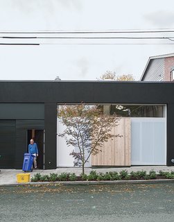 Perforated metal screens, one of which doubles as the front door, shield the storefront window from the street.
