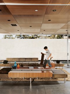 Matthew sets about finishing his latest knitting project while lounging on furniture of his dad’s design. A sound system and lighting by Halo are recessed into the ceiling.